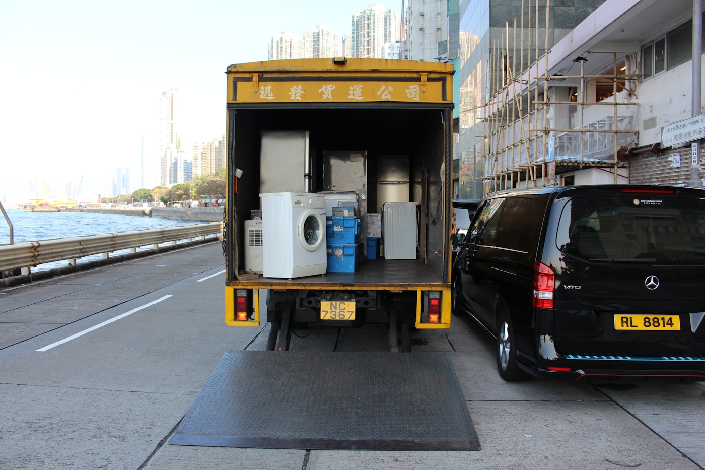 Delivery truck with liftgate open, loaded with a washing machine and refrigerator for residential appliance delivery